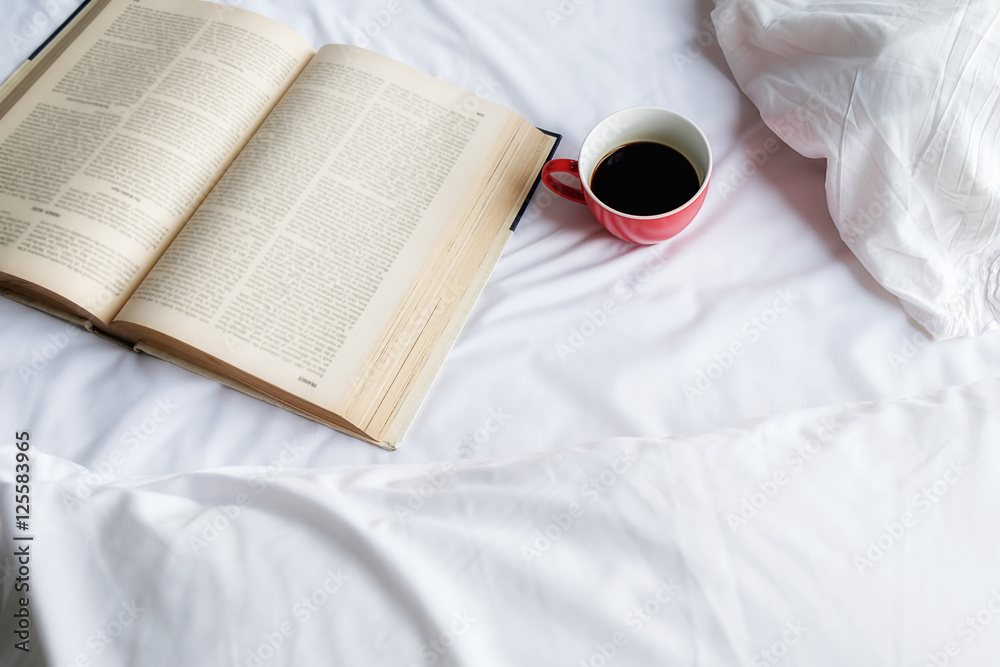 Book and cup on bad.Morning with a book. Relaxing concept. Retro filter effect,soft focus,selective focus.. Book and cup on bad.Morning with a book. Relaxing concept. Retro filter effect,soft focus,selective focus..