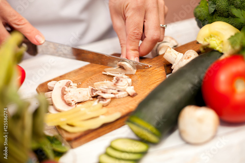 Woman in the kitchen cutting champignons