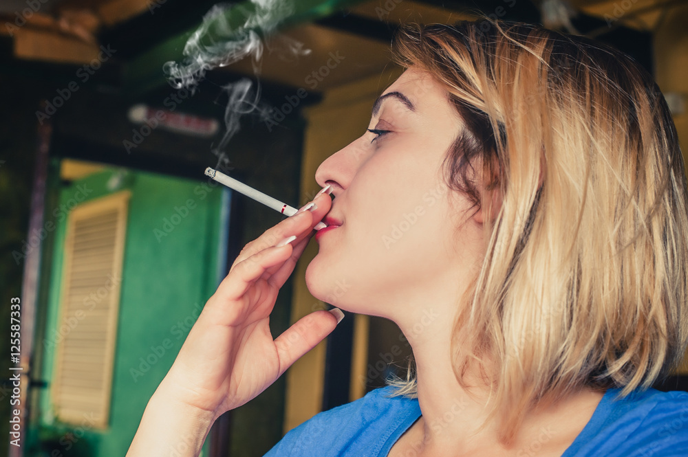 Fototapeta premium Beautiful girl pensive with her cigarette