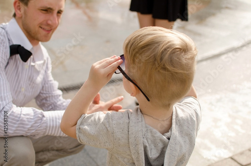 baby boy is walking in the park with his father