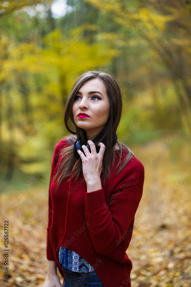 Young caucasian brunette woman with headphones outdoors on autum Young caucasian brunette woman with headphones outdoors on autum