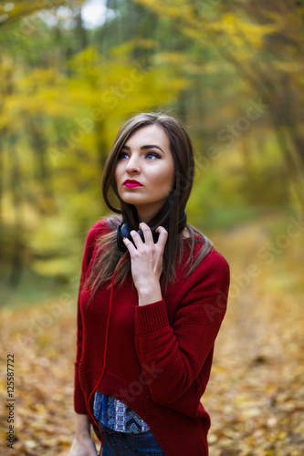 Young caucasian brunette woman with headphones outdoors on autum