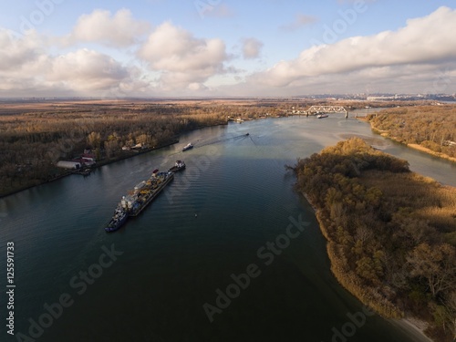 Fototapeta Naklejka Na Ścianę i Meble -  Cargo ship in beautiful river. Aerial view. Autumn landscape.    