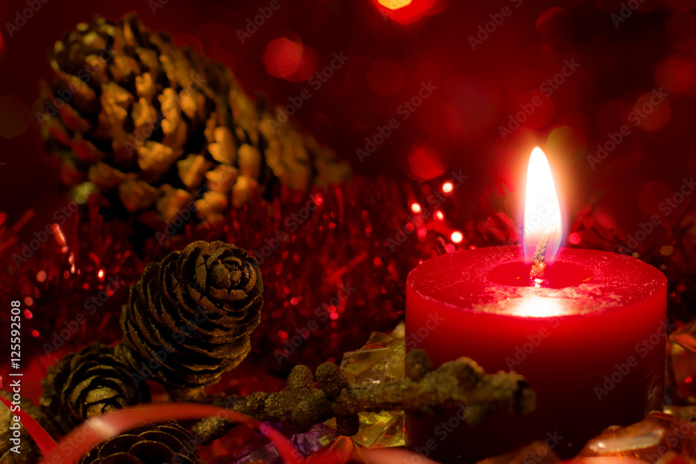 Christmas and New Year`s festive evening burning candle bokeh image. Greeting card dark Background concept with holiday tinsel, fir cones, tree branch and copyspace place for text or logo. - obrazy, fototapety, plakaty 