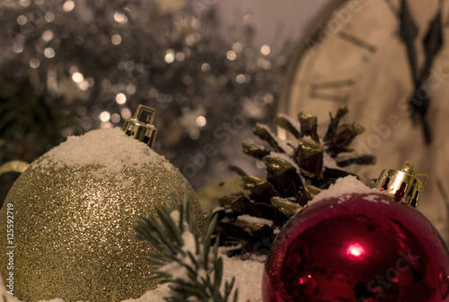 New Year's snowy background vintage clock showing five to midnight. Festive evening, Christmas toy balls, fir cones and fir branches covered with snow. 