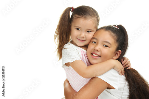 Happy funny girl sisters hugging isolated on a white background