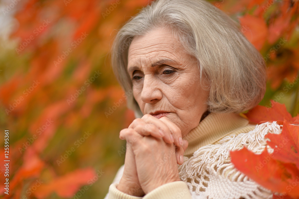 Sad elderly woman in autumn park Sad elderly woman in autumn park