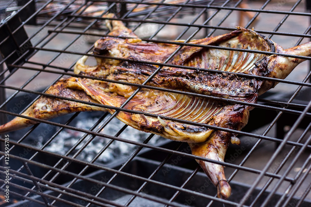Appetizing grilled lamb on the spit. Roasted pig on traditional barbecue. Roasting barbecue is prepared of a ram pig baked pork meat Street food Whole carcass pig roasting on the grill over charcoal.