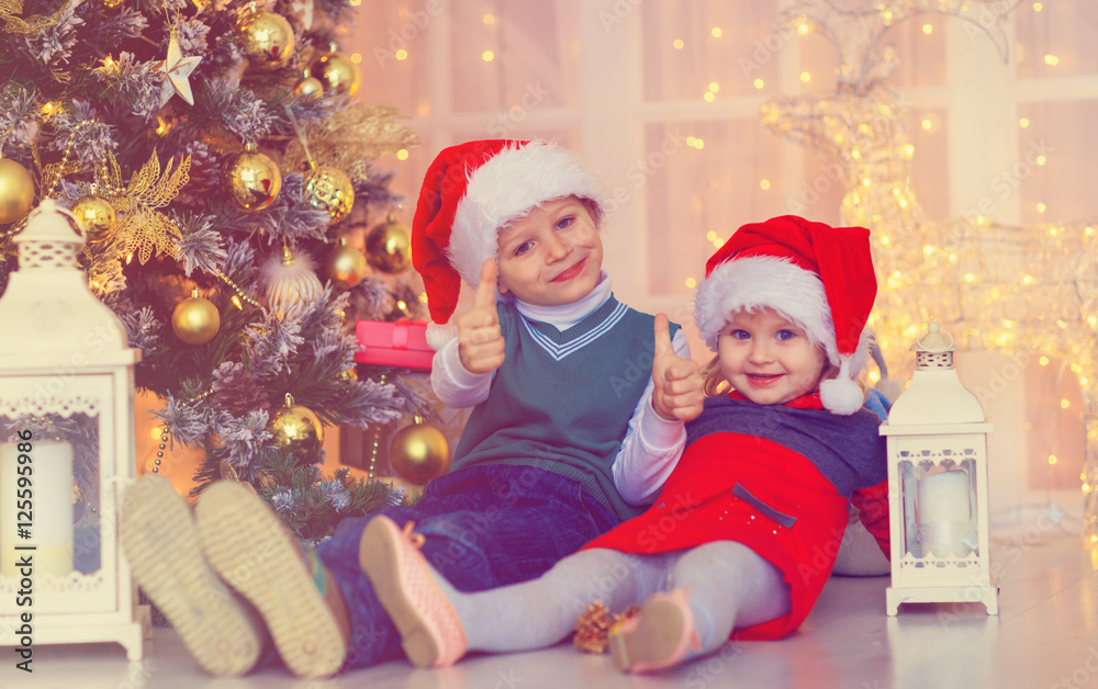 happy kids waiting for christmas presents in decorated living room