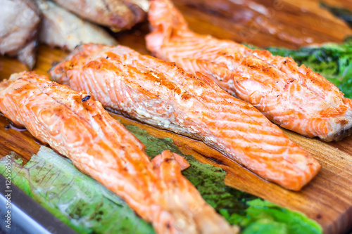 Fillet of salmon. Fresh and beautiful salmon fillet on a wooden table. Delicious fish meat. Grilled salmon on wooden cutting board.