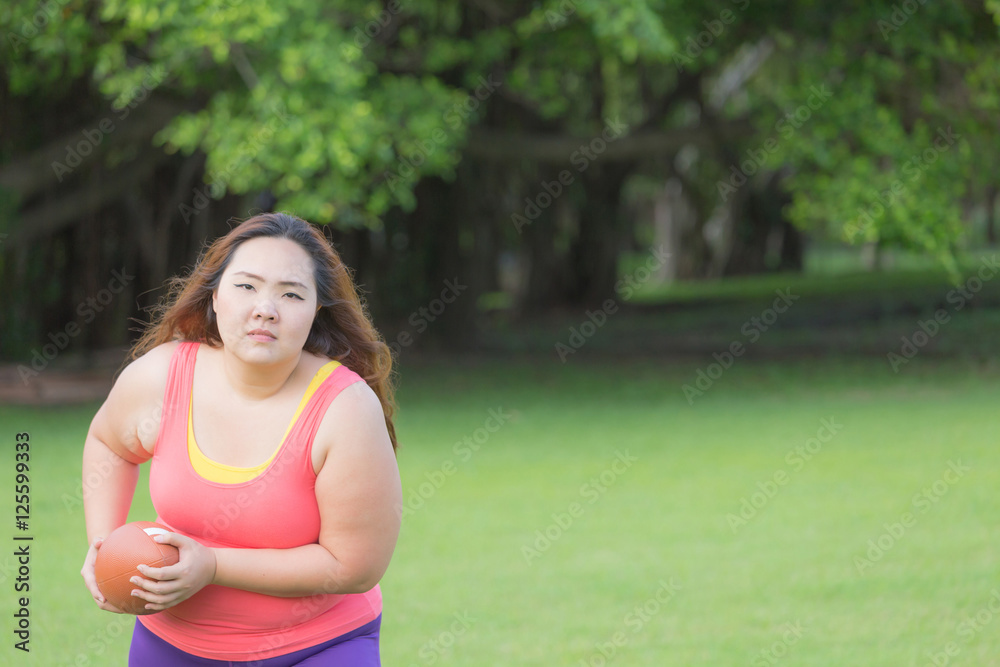 Beautiful fat woman playing american football in the park. Beautiful fat woman playing american football in the park.