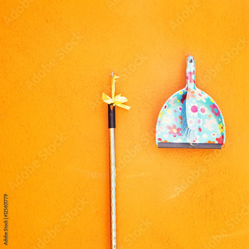 Abstract orange wall and cleaning utensil