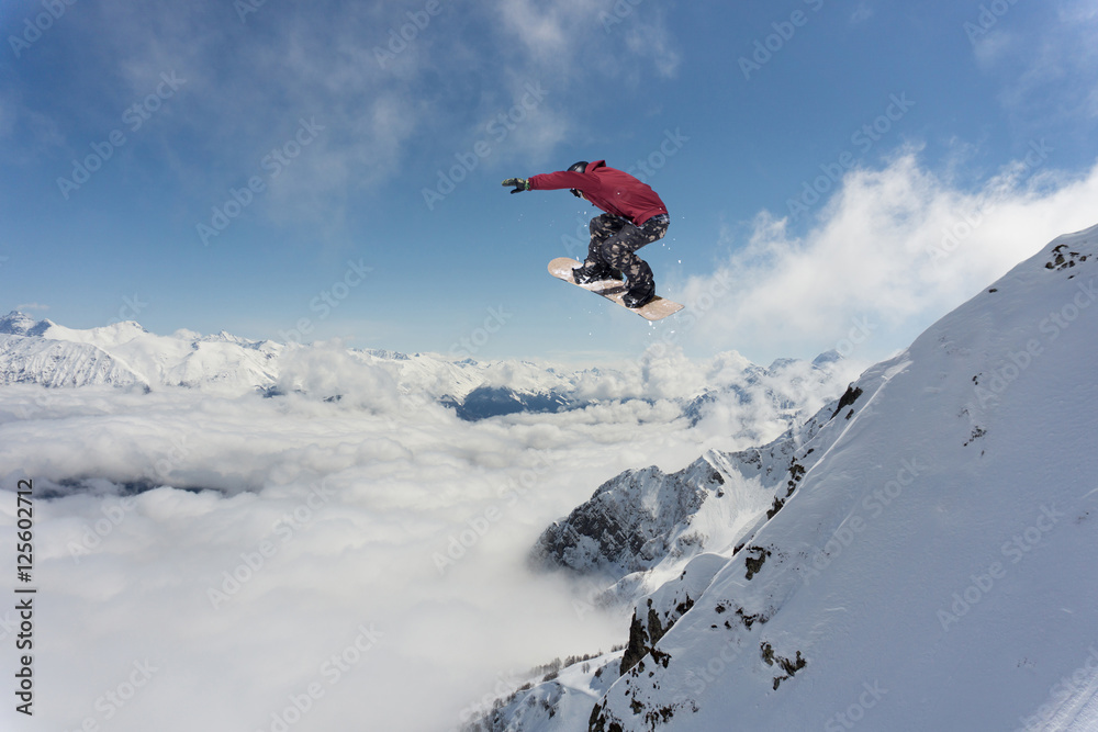 Snowboard rider jumping on mountains. Extreme snowboard sport.