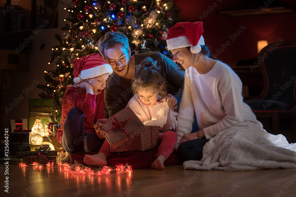 Obraz premium At christmas a lovely family find a digital tablet in their gift