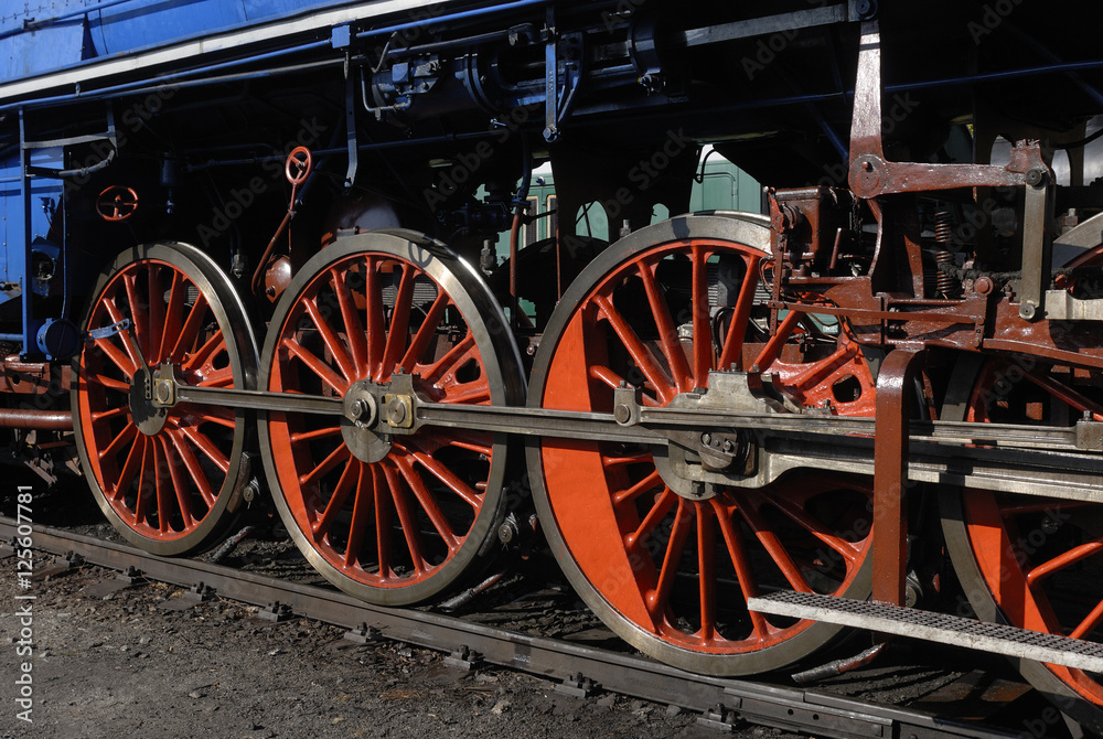 Steam locomotive wheels and rods closeup. Detail of mechanical parts, wheels and equipment of the train.
