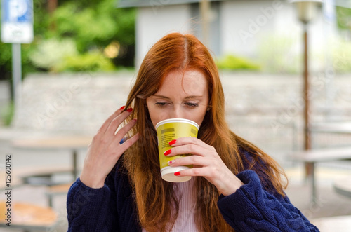 Young red woman with hot coffee