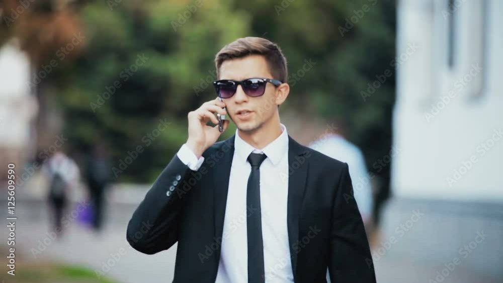 Young businessman talking on the phone. On the street. Young businessman talking on the phone. On the street.