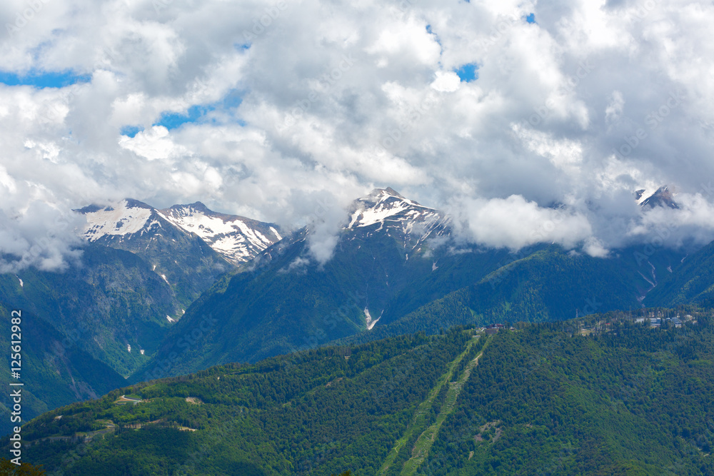 Big clouds over the snow-capped mountain peaks Big clouds over the snow-capped mountain peaks