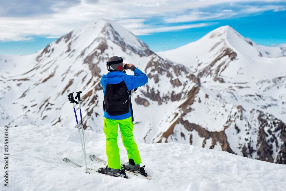 Skier making panorama shot of the mountains full of snow.