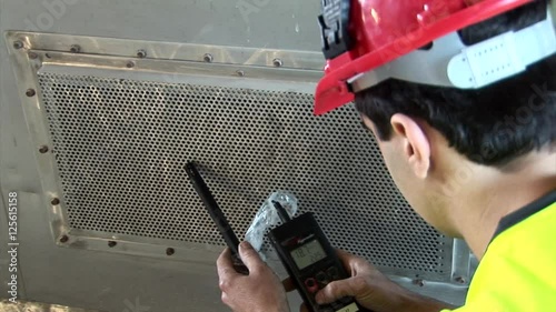 Over shoulder on professional testing air quality in ventilator shaft photo