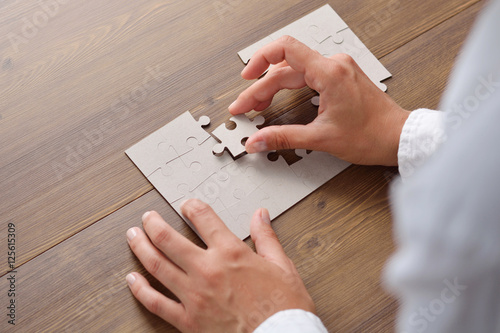 Folding puzzle hand parts on a wooden table photo