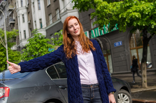 Young red woman is catching taxi