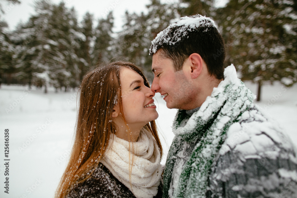 Young beautiful couple having fun and enjoying the snowy weather. Young beautiful couple having fun and enjoying the snowy weather.