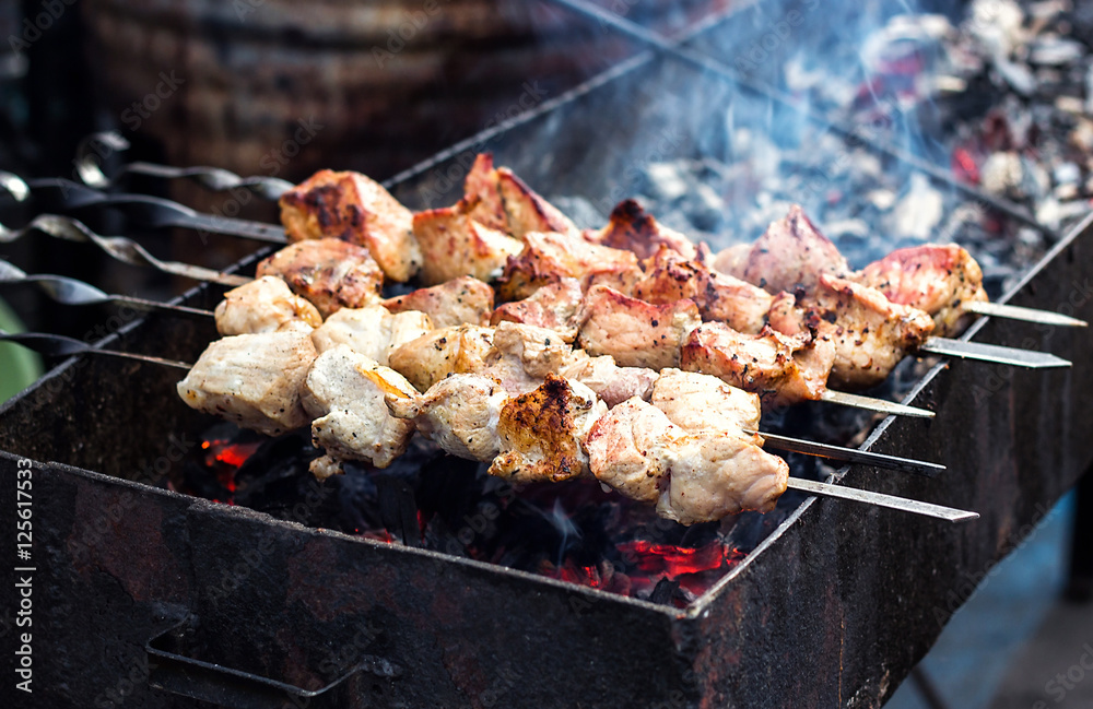Marinated shashlik preparing on a barbecue grill over charcoal. Shashlik or Shish kebab popular in Eastern Europe. Shashlyk (skewered meat) was originally made of lamb. Roast Beef Kebabs On BBQ Grill.