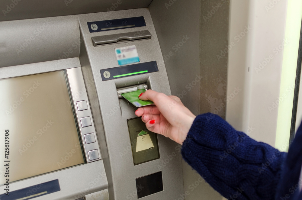 Young red woman using the cash machine Young red woman using the cash machine