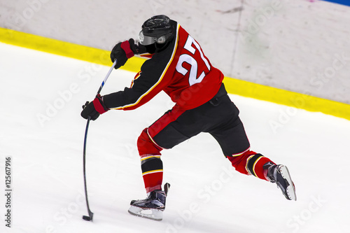 Ice hockey player shoots the puck photo
