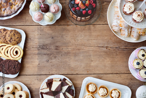 Table with cake, pie, cupcakes, tarts and cakepops. Copy space. photo