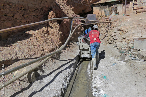 Silver miners pushing the cart into the mines of cerro Rico, Potosi Bolivia photo