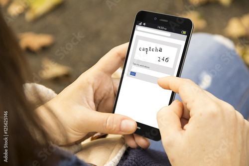 woman with captcha phone in the park photo