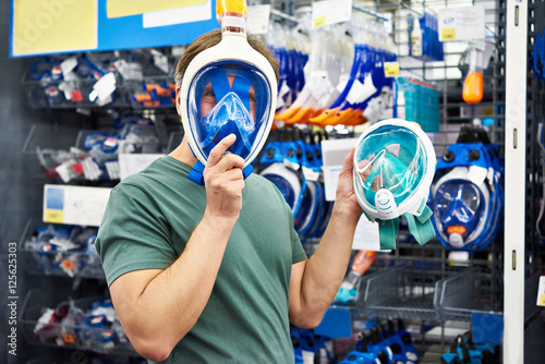 Man chooses mask for scuba diving in store