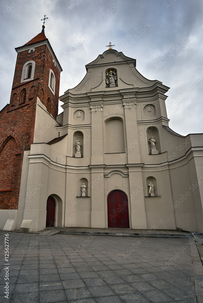 Baroque facade of the church with a Gothic bell tower in Gniezno.