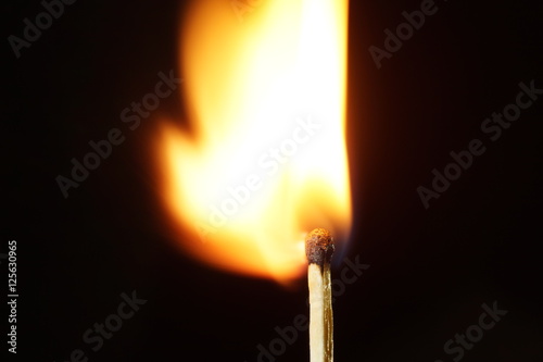 A burning matchstick in the dark environment