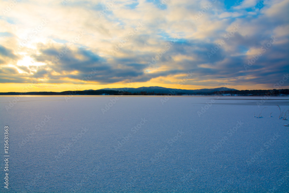 Frozen lake on the background of Ural mountains