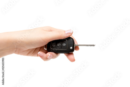 Female hand holds car keys on white background.