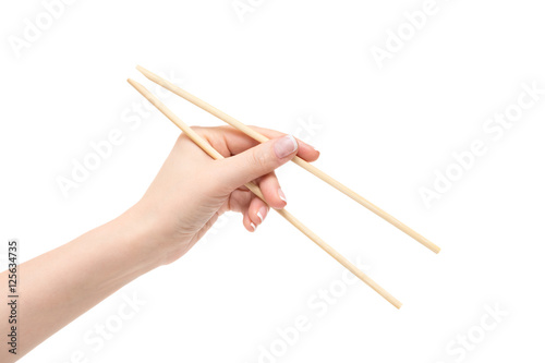 Female hand holds chopsticks on a white background.