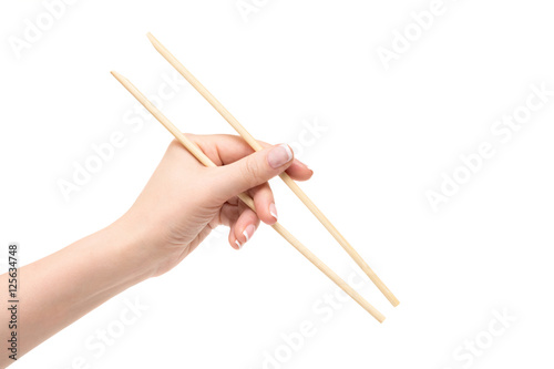 Isolated female hand holds chopsticks on a white background.