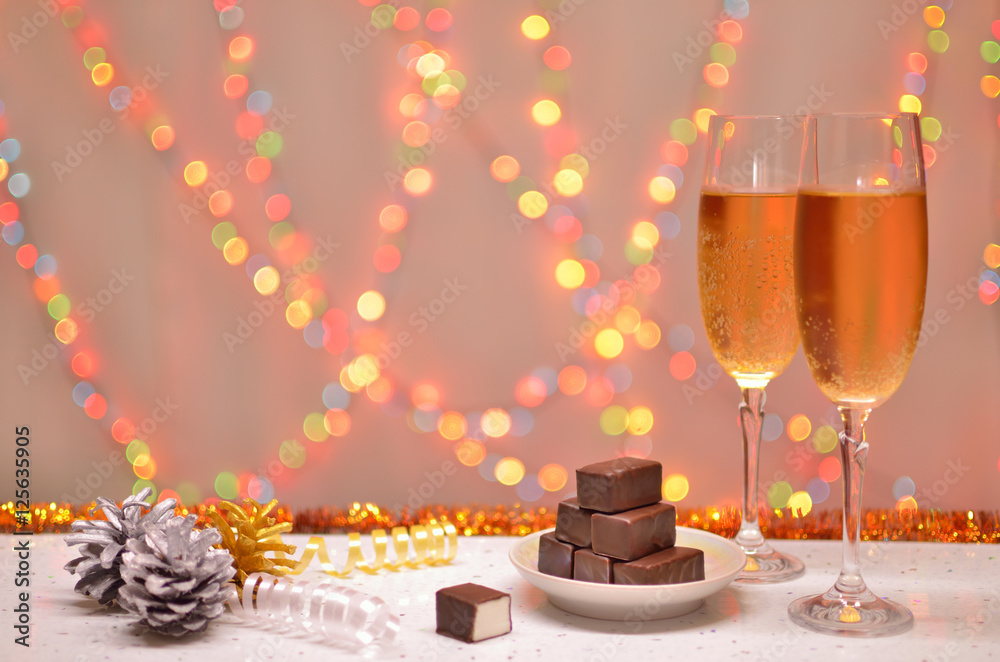 Glass champagne and chocolate on the christmas background spots light