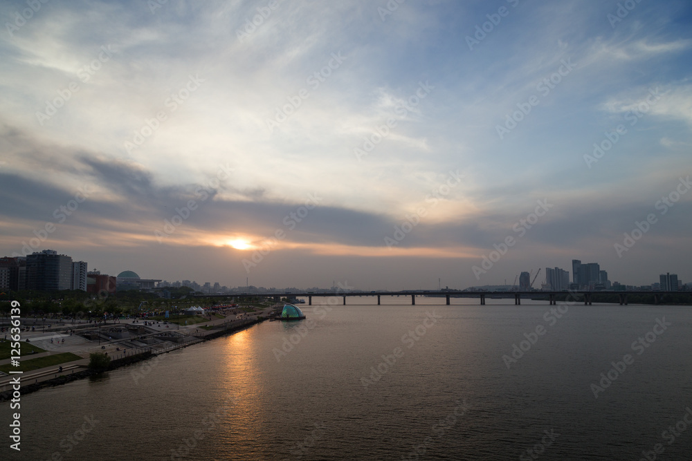 View of a park in the river shore and bridge at the Han River in Seoul, South Korea, at sunset. Copy space.