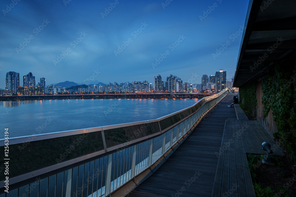 View of a residential district along the Han River and wooden boardwalk at the Mapo Bridge in Seoul, South Korea, in the evening. Copy space.