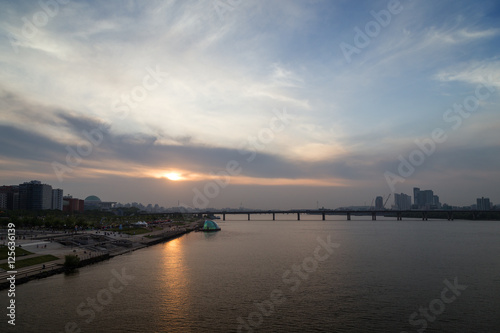 View of a park in the river shore and bridge at the Han River in Seoul, South Korea, at sunset. Copy space. © tuomaslehtinen