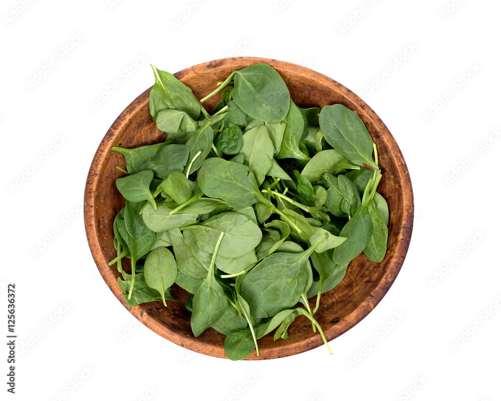 Spinach organic baby leaves in wooden bowl isolated on white background Spinach organic baby leaves in wooden bowl isolated on white background