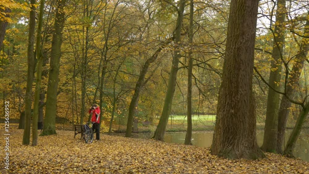 Gamer Puts on 360Vr Glasses Outdoors Watching Video 360 Degrees Playing Virtual Games Autumn Landscape Park by Lake Cyclist is Resting Bicycle at the Bench Gamer Puts on 360Vr Glasses Outdoors Watching Video 360 Degrees Playing Virtual Games Autumn Landscape Park by Lake Cyclist is Resting Bicycle at the Bench
