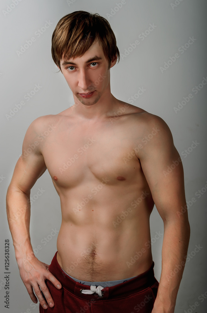 European young guy stripped to the waist with a press looking confident
