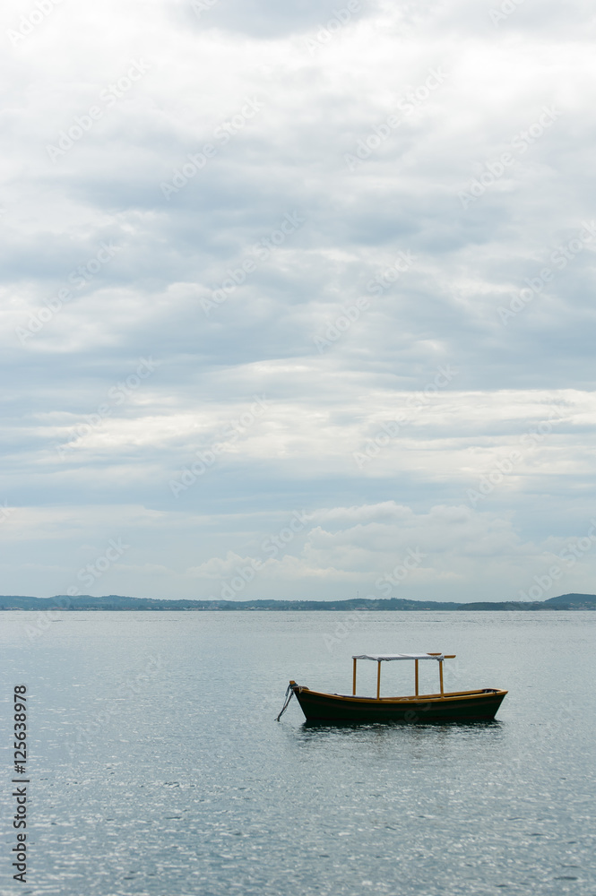 Small boat anchored near shore on calm sea