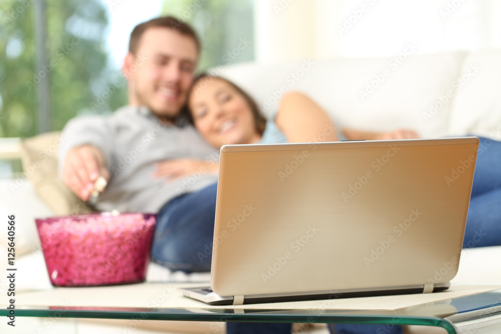 Couple watching tv in a laptop at home Couple watching tv in a laptop at home