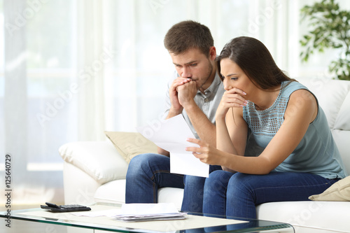 Worried couple reading a letter photo